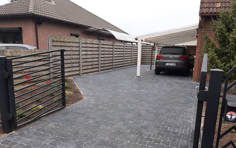 Bestrating voor aanleg oprit en carport naast huis in Brecht door Tuinaanleg Damen
