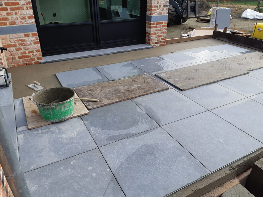 Bestrating tuin met grote keramieken tegels als terras voor huis in Brecht
