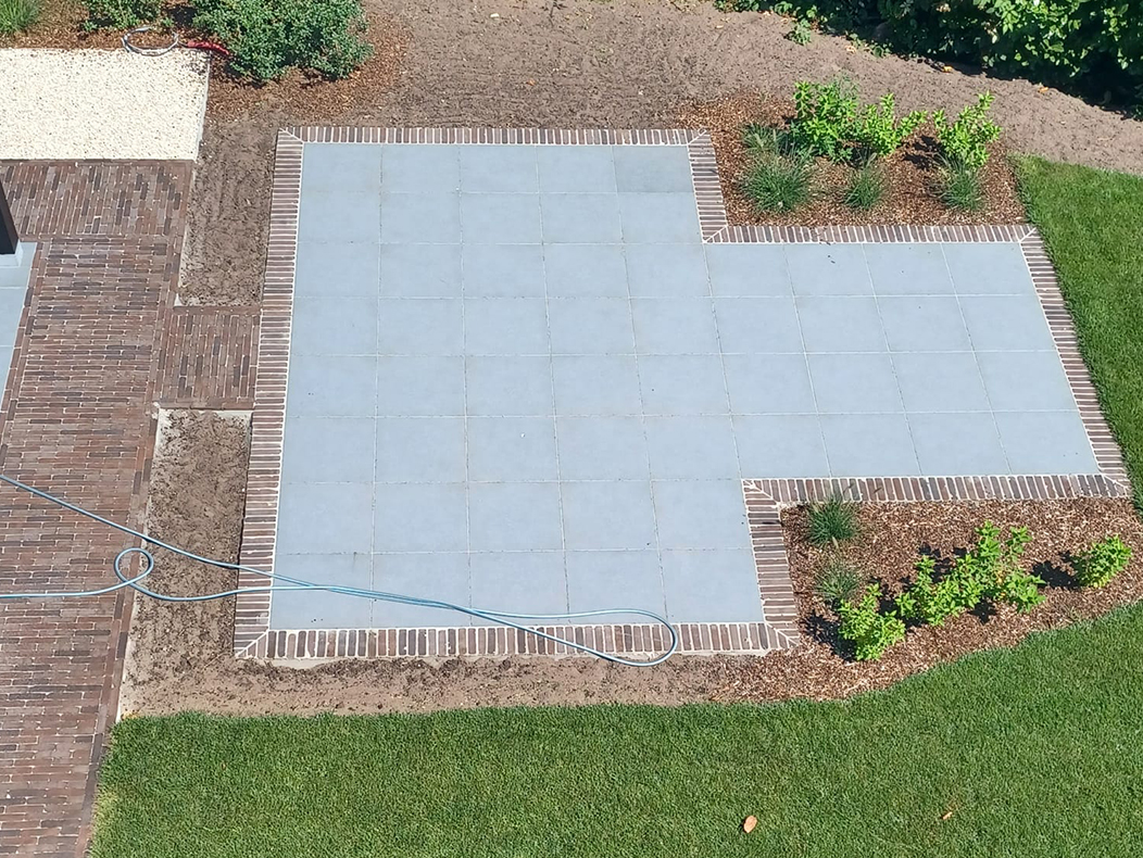 Bestrating met klinkers en keramieken tegels voor dubbel terras in grote tuin in Hoogstraten