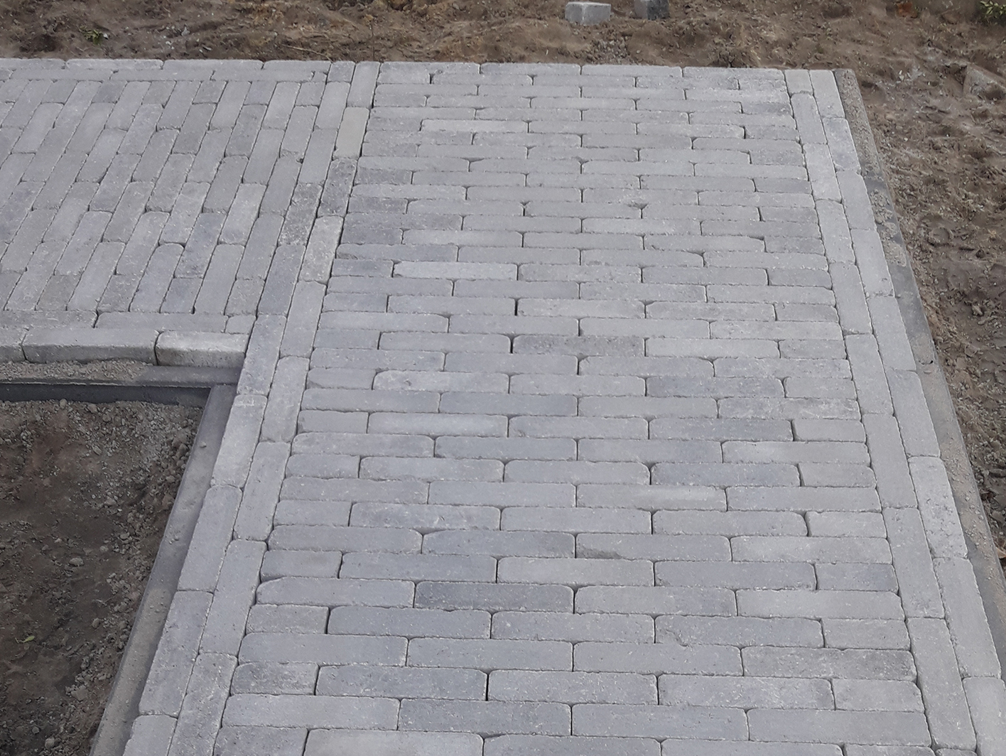 Bestrating tuin klinkers grijs met boordsteen bij nieuwbouwtuin in Brecht