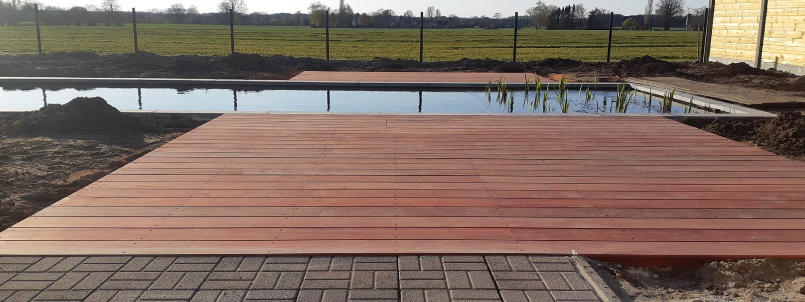 Tuinrenovatie van vijver met bankirai terras in achtertuin Loenhout